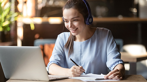 A female using her laptop with a headset on